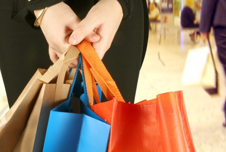 Person holding multicolored shopping bags