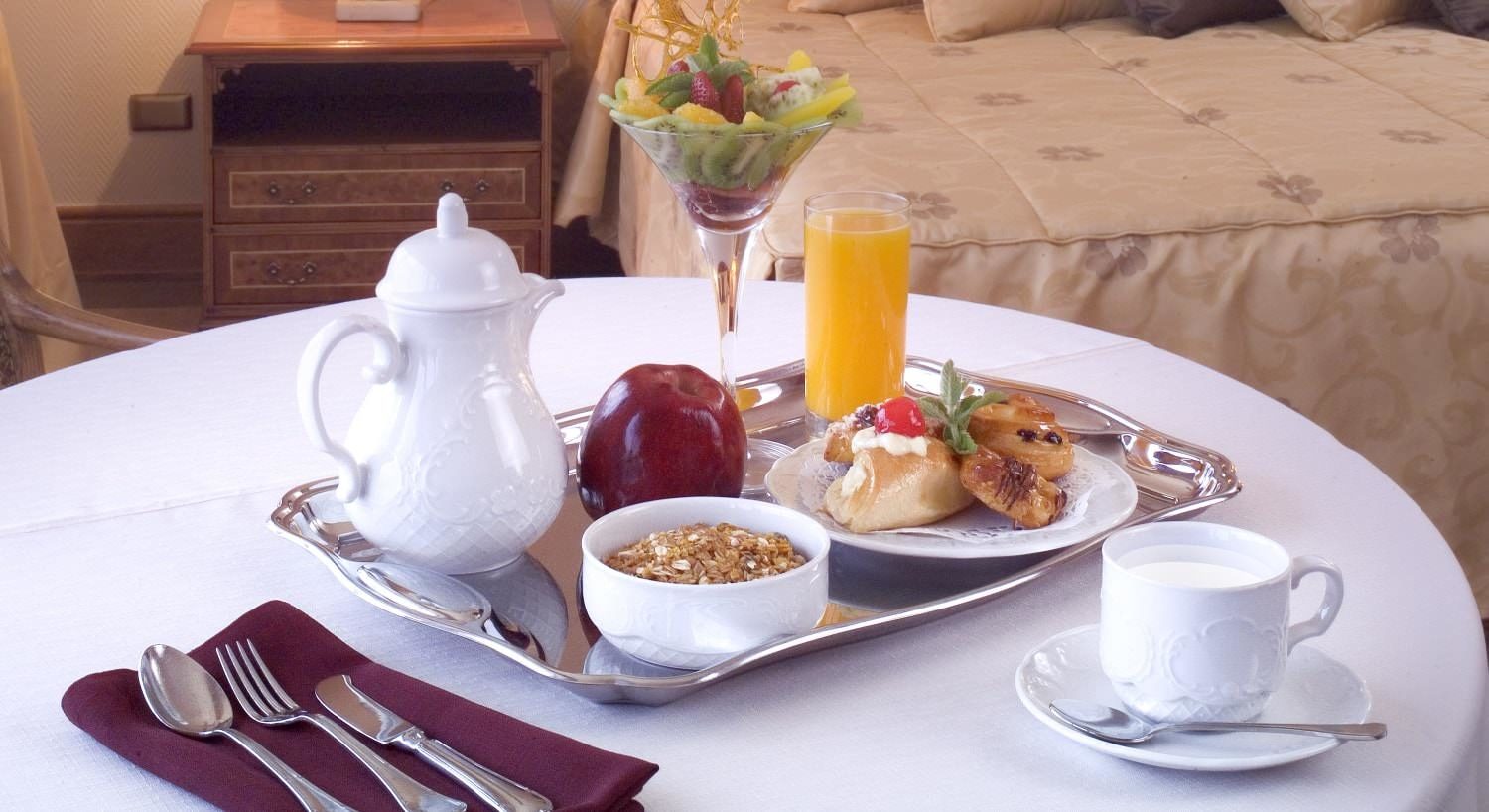 Silver tray with breakfast items on table with white tablecloth