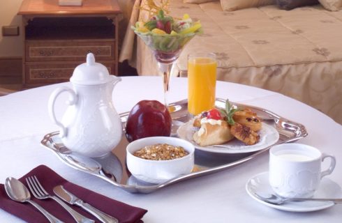 Silver tray with breakfast items on table with white tablecloth