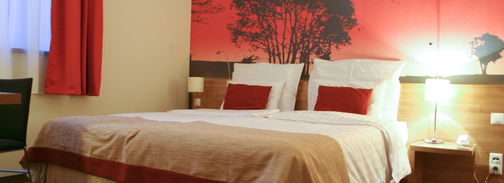 Bedroom with light brown furniture and white linens