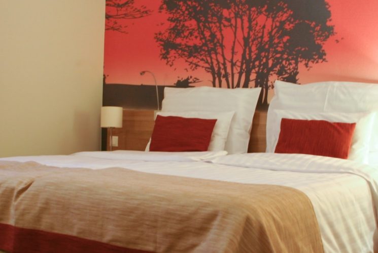 Bedroom with light brown furniture and white linens