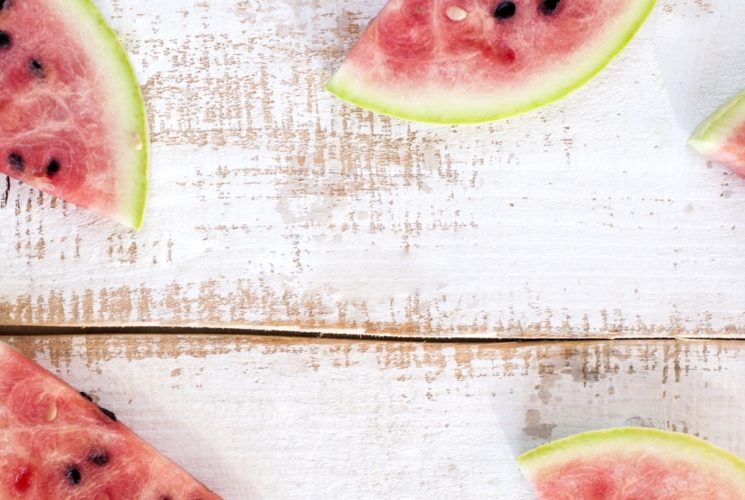 Slices of watermelon on top of white-washed wood